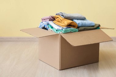 Renkli duvarın yanında giysileri olan gardırop kutusu.