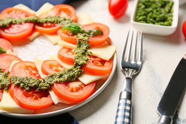 Caprese salatası ve pesto soslu tabak, yakın plan.