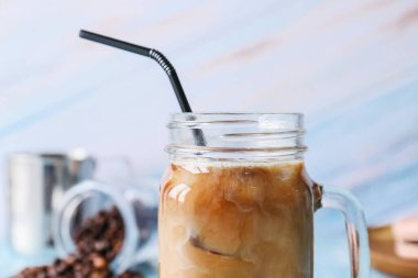 Mason kavanozu buzlu kahve. Arka planda süt var.