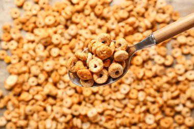 Lezzetli mısır gevreği halkaları ile kaşık, yakın çekim.