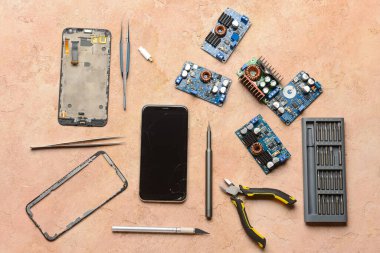 Renk arkaplan üzerinde teknisyen araçları olan parçalanmış cep telefonu