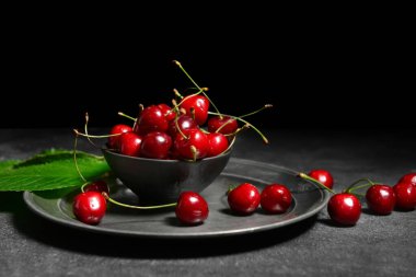 Koyu arkaplanda vişneli kase