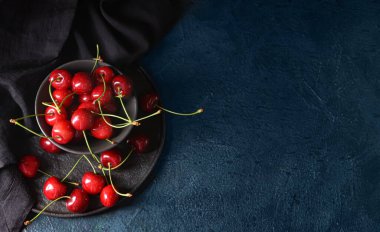 Koyu arkaplanda vişneli kase