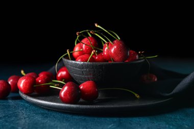 Koyu arkaplanda vişneli kase