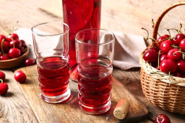 Tahta arka planda bir bardak tatlı kiraz şarabı.