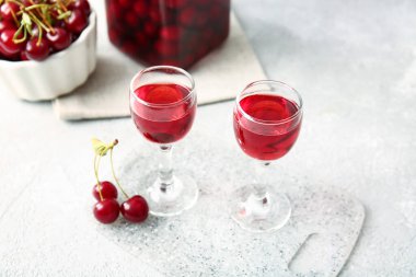 Hafif arka planda bir bardak vişne şarabı.