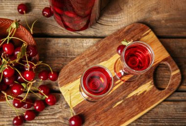 Ahşap zemin üzerinde vişne şarabı kadehleriyle kompozisyon