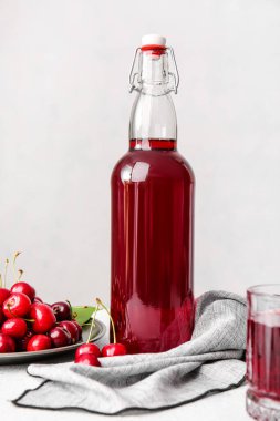 Hafif arka planda bir şişe vişne şarabı