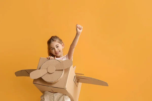 Küçük Kız Renkli Arka Planda Karton Uçakla Oynuyor — Stok fotoğraf