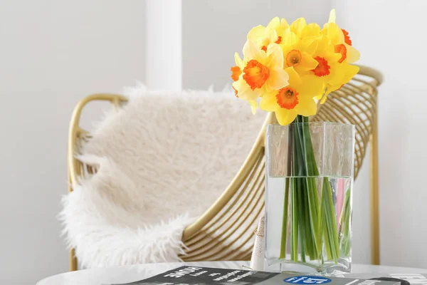 部屋のテーブルの上に美しい水仙や雑誌と花瓶 — ストック写真
