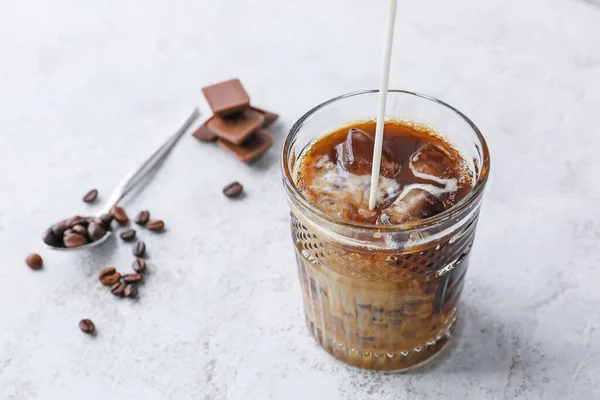 Versare Latte Nel Bicchiere Con Caffè Ghiacciato Fondo Chiaro — Foto Stock