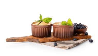 Beyaz arkaplanda yabanmersinli turta ile Ramekinler