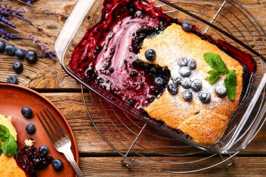 Ahşap arka planda yabanmersinli turta pişirme.