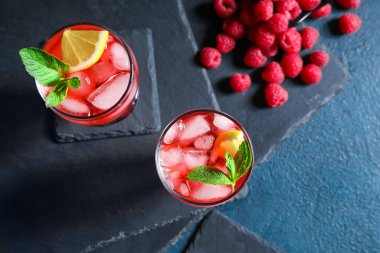 Koyu arkaplanda lezzetli ahududu limonatalı bardaklar.