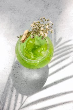 Lezzetli bir kokteyl ve arka planda güzel çigila çiçekleri.