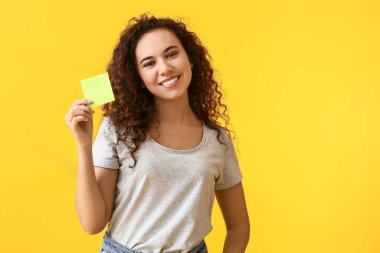 Renk arkaplanında çıkartma notu olan genç bir kadın