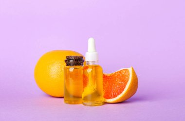 Renkli arka planda gerekli yağ ve greyfurt şişeleriyle kompozisyon