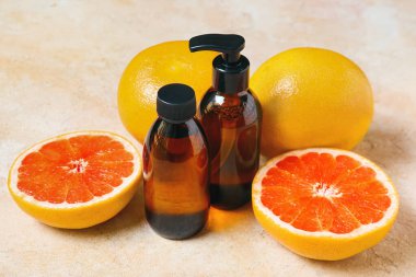 Renkli arka planda gerekli yağ ve greyfurt şişeleri