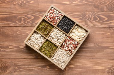 Ahşap arka planda farklı baklagiller olan kutu