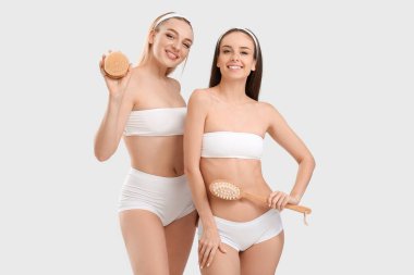 Masaj fırçaları açık arkaplanda güzel genç kadınlar.