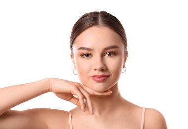 Güzel genç bir kadın beyaz arka planda yüzüne masaj yapıyor.