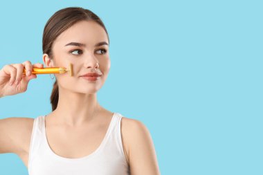 Renkli yüz masajı aracı olan güzel bir genç kadın.