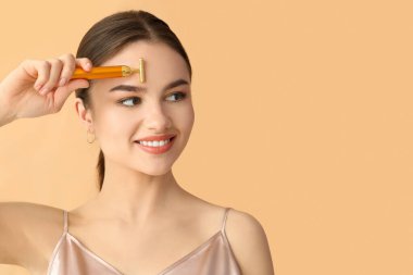 Renkli yüz masajı aracı olan güzel bir genç kadın.