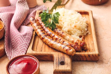 Lezzetli ızgara sosis, lahana turşusu ve soslu bir pano.