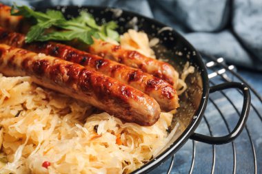 Lezzetli ızgara sosis ve lahana turşulu kızartma tavası, yakın plan.