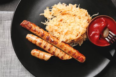 Lezzetli lahana turşulu tabak, ızgara sosis ve sos, yakın plan.