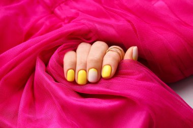 Güzel manikürlü ve elbiseli kadın eli, yakın plan.