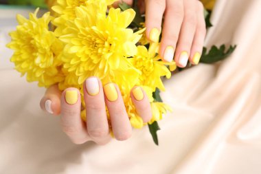 Güzel manikürlü kadın elleri ve renkli arka planda çiçekler, yakın plan.