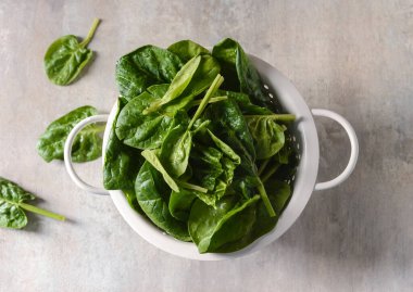 Hafif arka planda taze ıspanak yapraklı kolander.