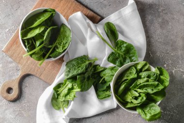 Arkaplanda taze ıspanak yaprakları olan kaseler.