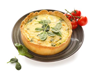 Beyaz arka planda lezzetli ıspanaklı tart ve domates tabağı.