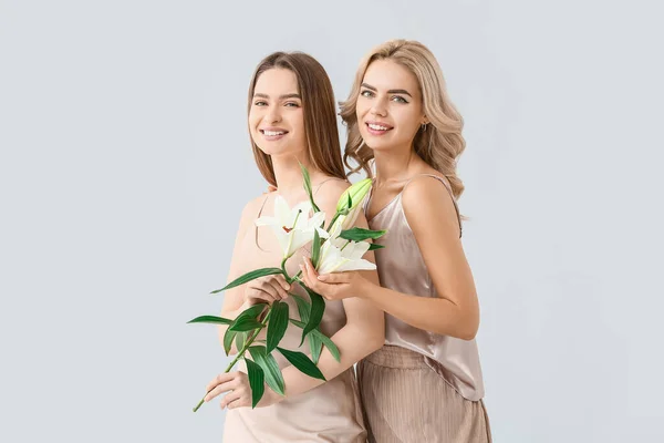 Hermosas Hermanas Jóvenes Con Flores Sobre Fondo Claro — Foto de Stock