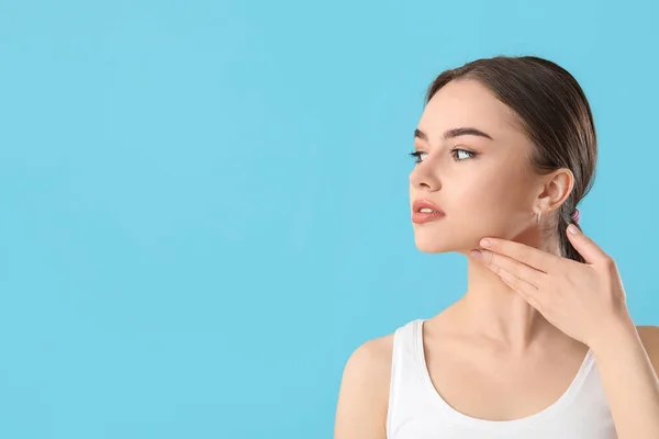 Hermosa Joven Masajeando Cara Sobre Fondo Color — Foto de Stock