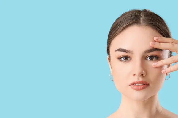 Hermosa Joven Masajeando Cara Sobre Fondo Color — Foto de Stock