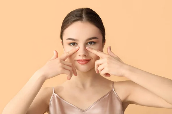 Hermosa Joven Masajeando Cara Sobre Fondo Color — Foto de Stock