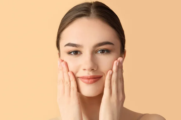 Hermosa Joven Masajeando Cara Sobre Fondo Color — Foto de Stock