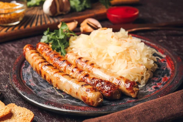 Teller Mit Leckeren Grillwürsten Und Sauerkraut Auf Dunklem Hintergrund Nahaufnahme — Stockfoto