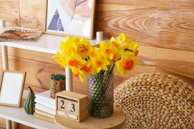 Narcissus çiçekli vazo ve masada takvim.