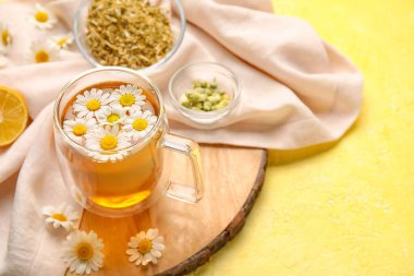 Renkli arkaplanda papatya çayı ve çiçekli kompozisyon