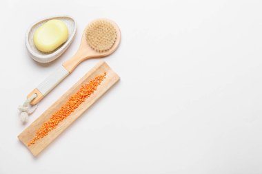 Masaj fırçası ve gri arka planda farklı banyo malzemeleri.