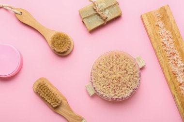 Renkli arkaplanda farklı masaj fırçaları ve banyo malzemeleri