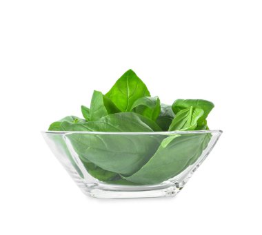 Beyaz arka planda taze fesleğen yapraklı cam kase.