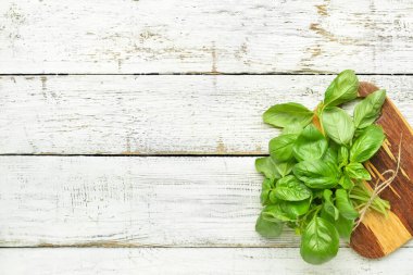 Hafif ahşap arka planda taze fesleğen yaprakları olan tahta.