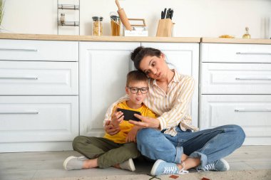 Genç kadın ve küçük oğlu evde selfie çekiyorlar.