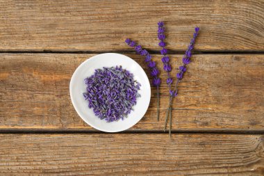 Ahşap arka planda güzel lavanta çiçekleri olan bir kase.