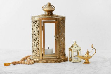 Işık arka planında Aladdin lambası ve tasbih olan Müslüman fenerler